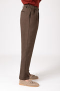 Man wearing brown wool French pencil pants in side profile view