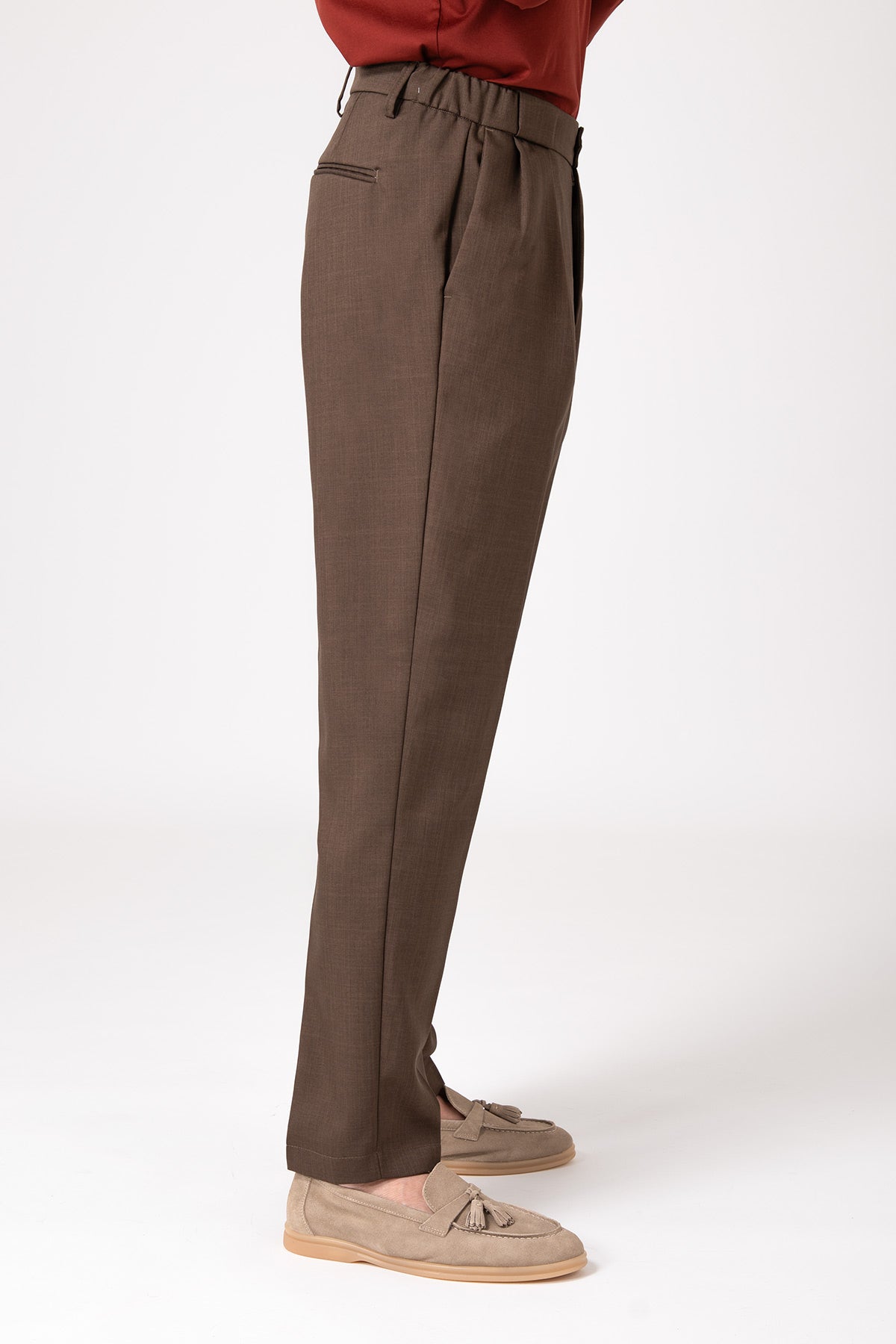 Man wearing brown wool French pencil pants in side profile view