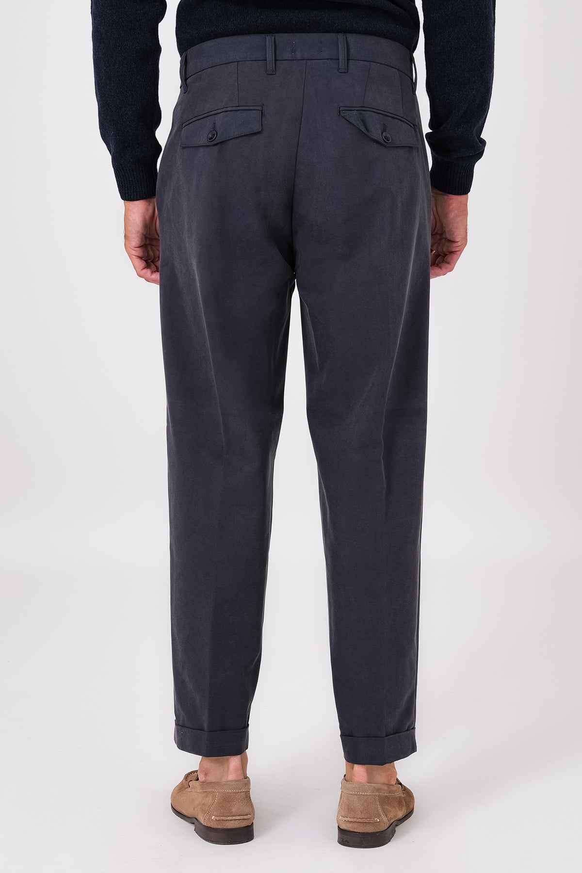 Vista posteriore del pantalone blu indossato, con tasche a filetto e risvolto sul fondo