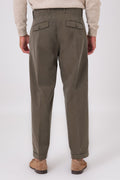 Vista posteriore del pantalone color militare indossato, con tasche posteriori e fondo con risvolto