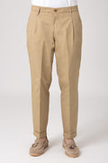 Man wearing high-waisted beige pants with darts front view
