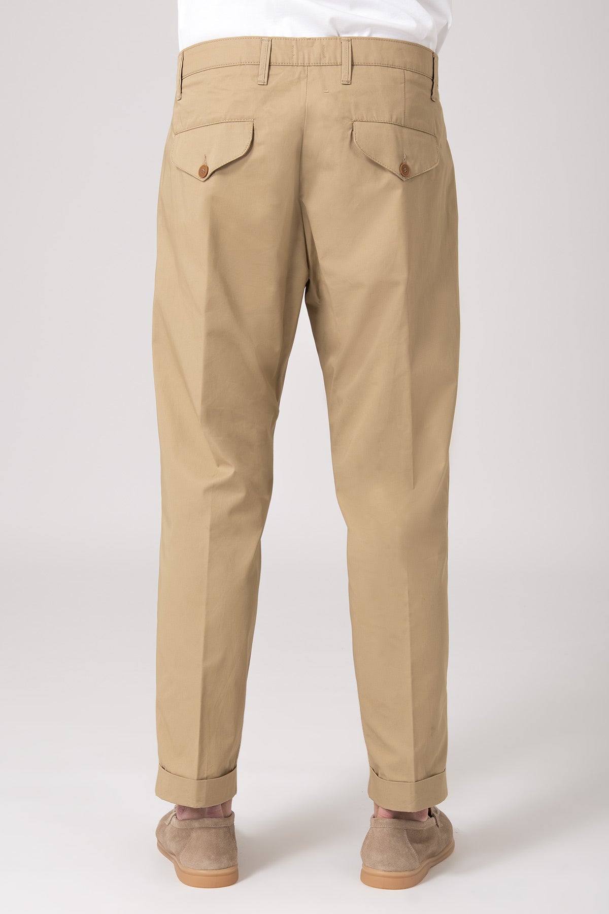 Man wearing beige high-waisted trousers with darts back view