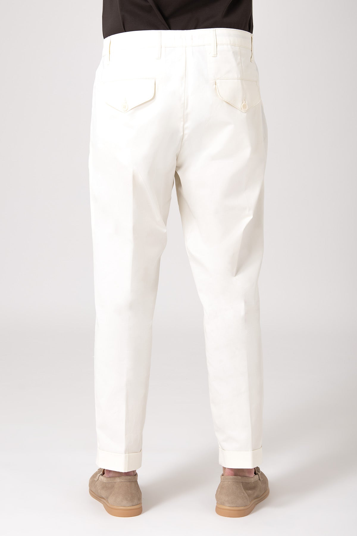 Man wearing white high-waisted pants with darts, back view