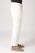 Man wearing beige high-waisted pleated pants side view