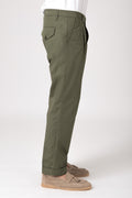 Side view of a man wearing green high-waisted pants with darts