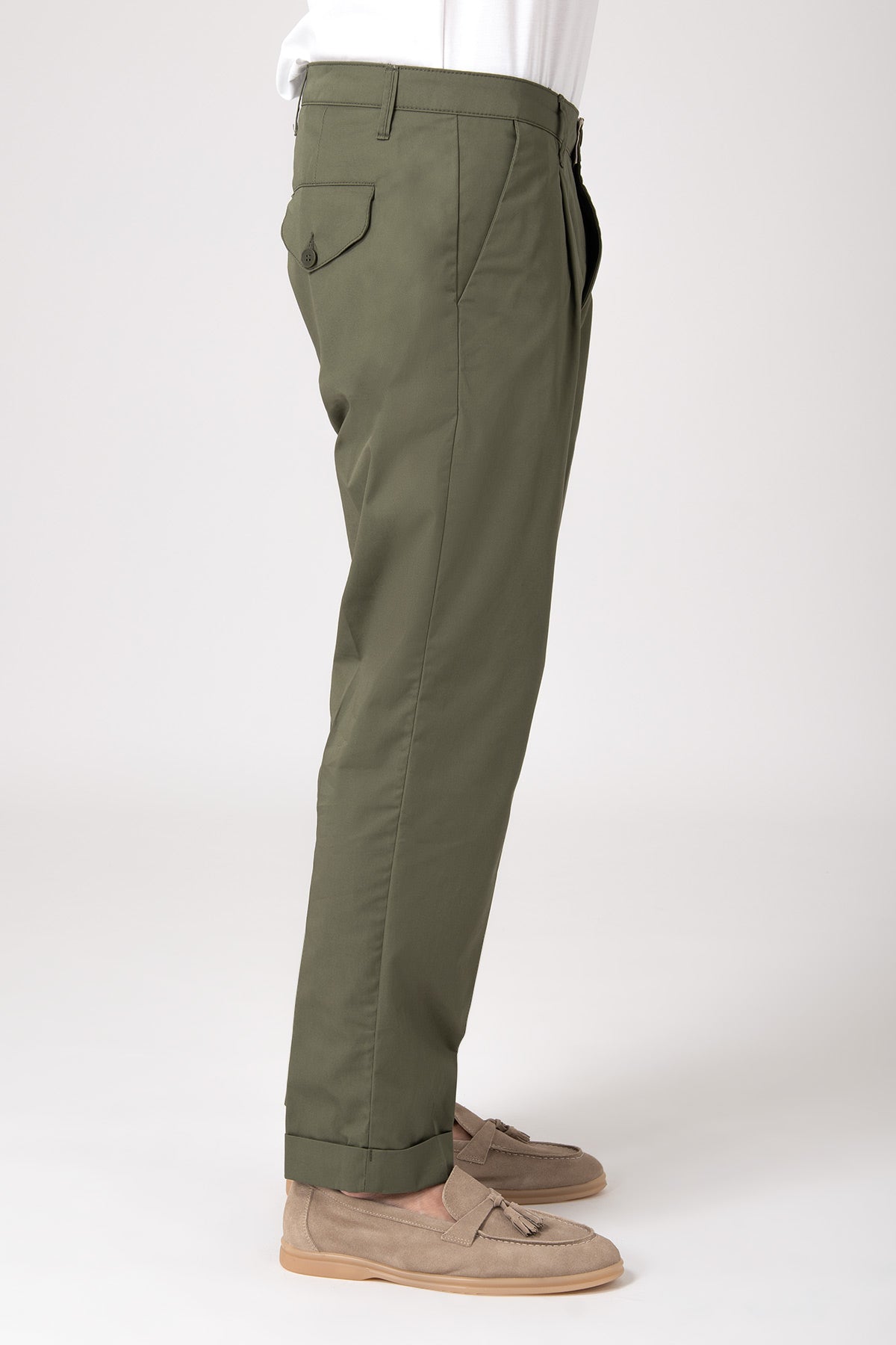 Side view of a man wearing green high-waisted pants with darts