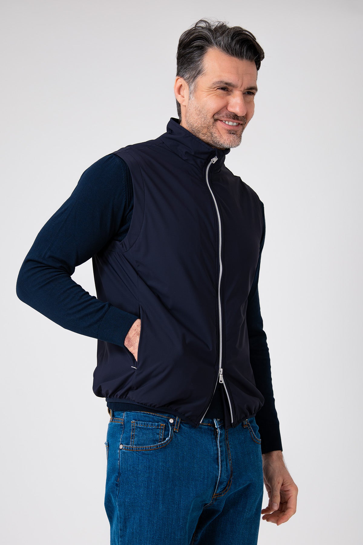 Uomo che indossa uno smanicato color blu navy con zip, vista di tre quarti