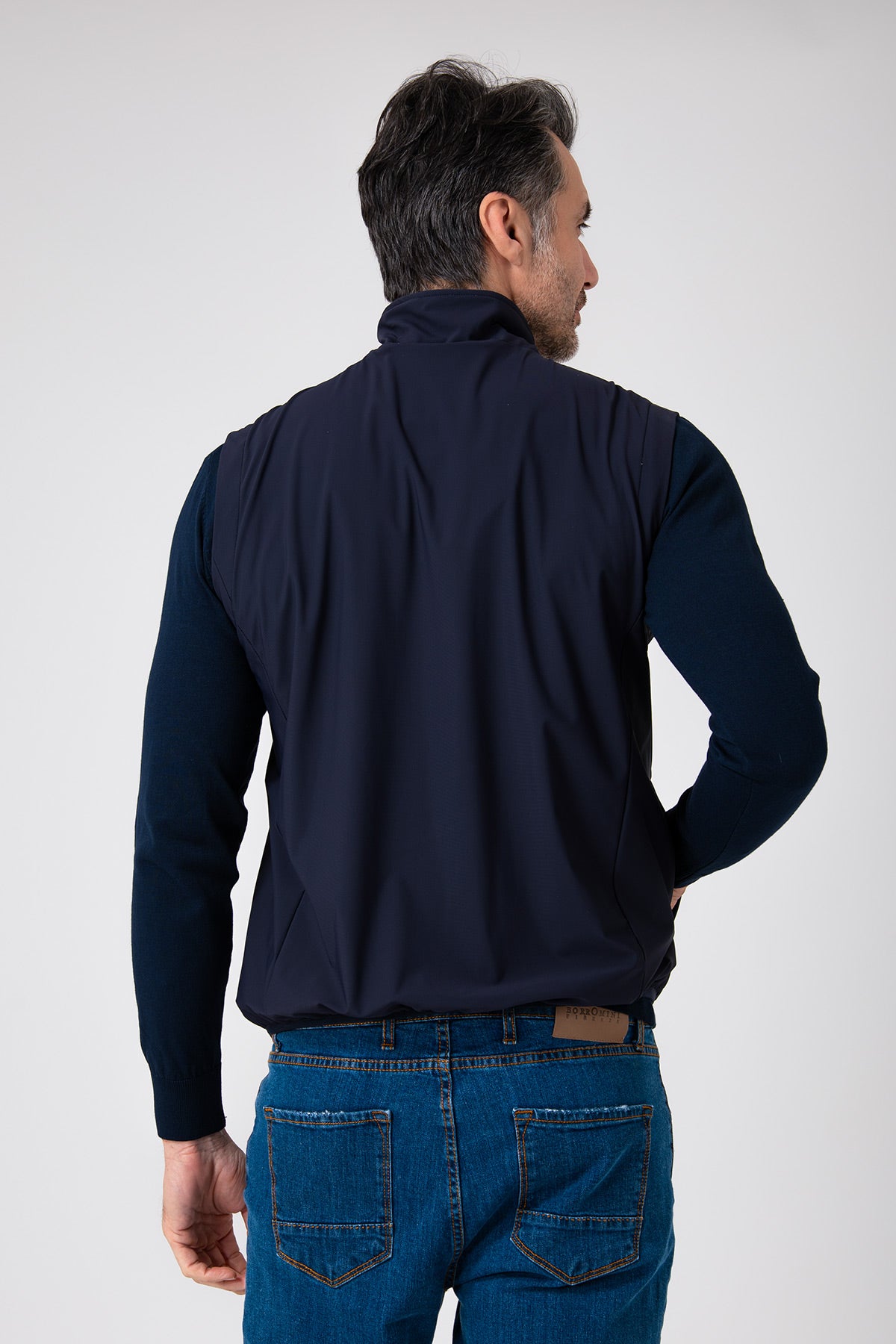 Uomo visto da dietro che indossa uno smanicato color blu navy con zip