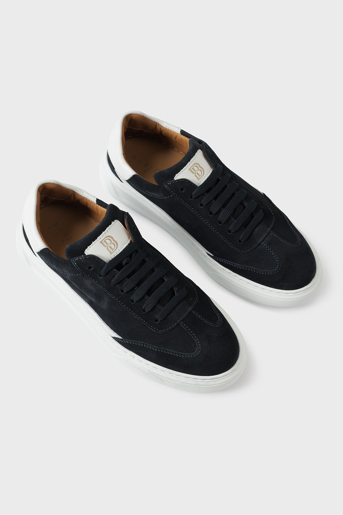 Low-top blue suede trainers with a white cupsole and lace-up front