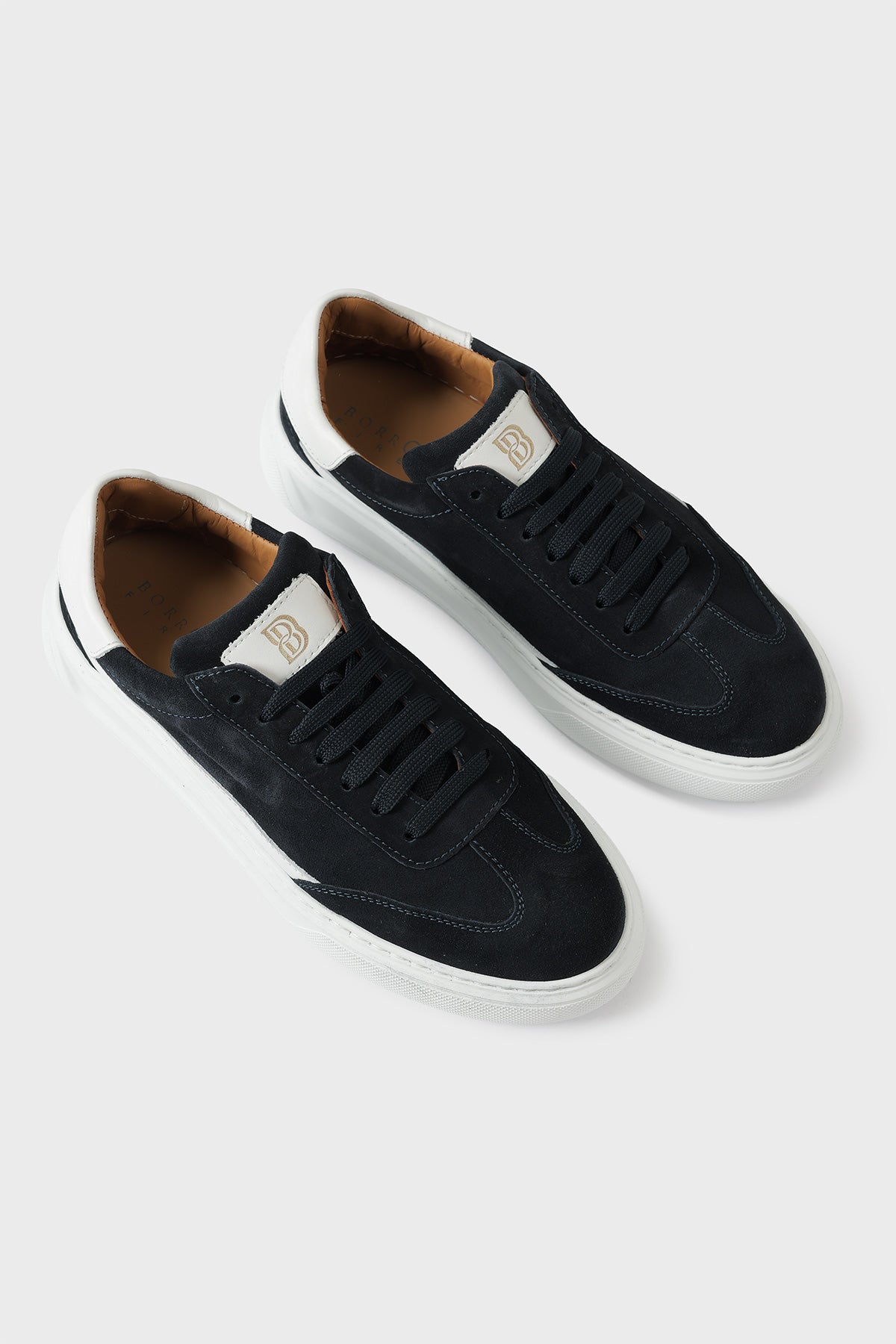 Low-top blue suede trainers with a white cupsole and lace-up front