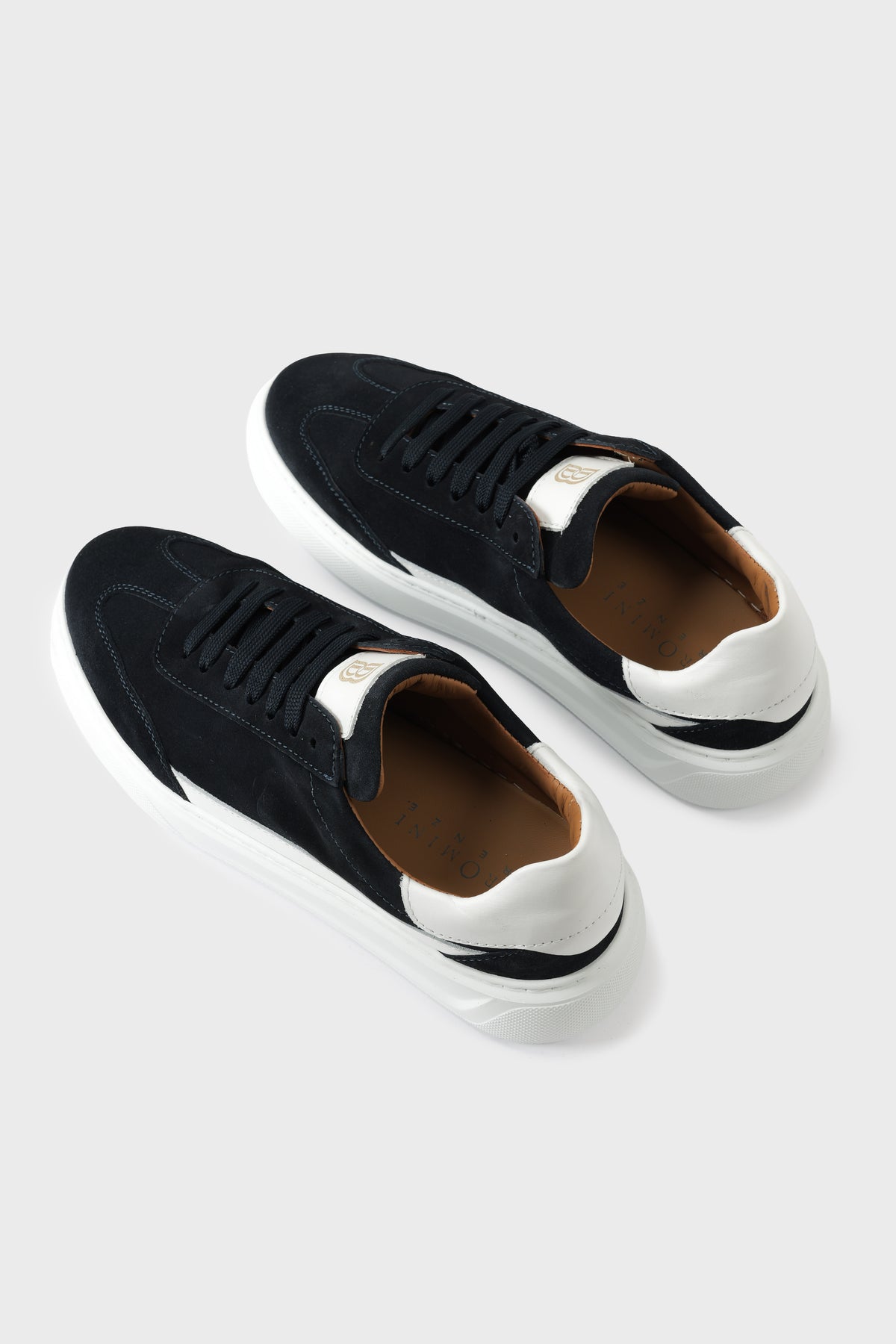 Three-quarter high-angle view of blue suede trainers with a contrasting white sole