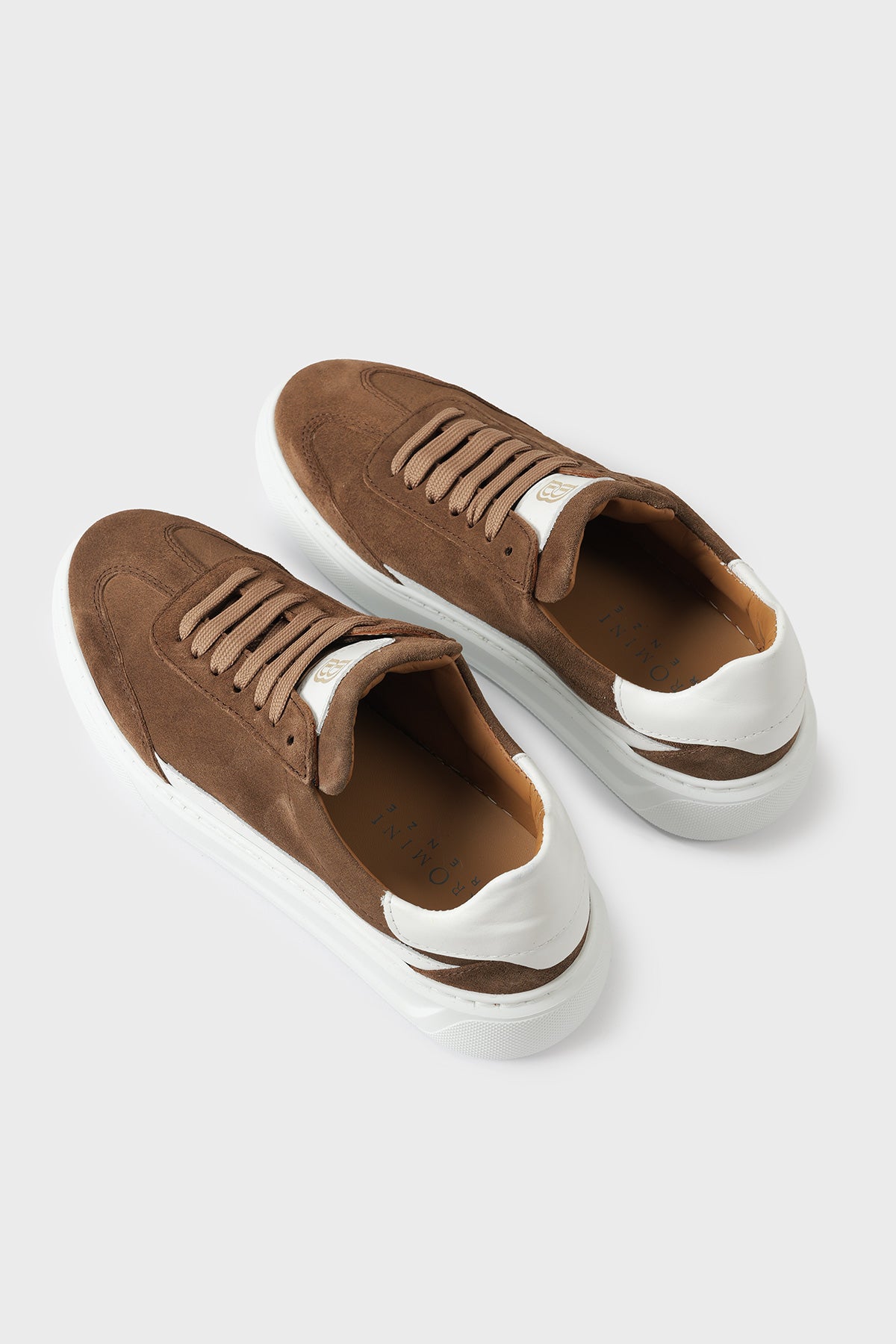 Top view of a pair of tobacco brown suede sneakers with white cupsoles