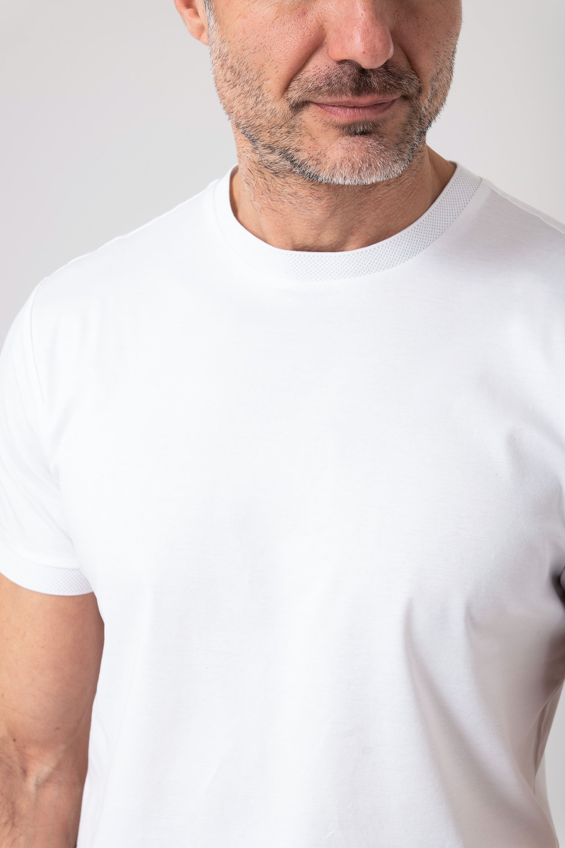 Front view of man wearing white mercerized cotton t-shirt with visible neckline