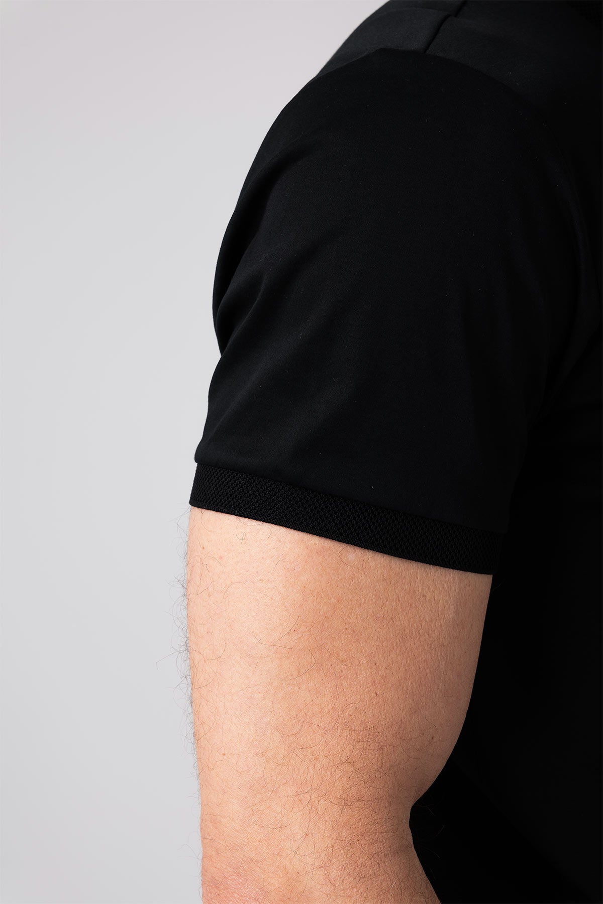 Man wearing black mercerized cotton t-shirt close-up side view of arm